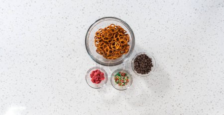 Foto de Flat lay. Measured ingredients in glass mixing bowls to make a chocolate pretzel Christmas wreath. - Imagen libre de derechos