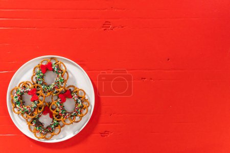 Foto de Flat lay. Chocolate pretzel Christmas wreath on a white plate. - Imagen libre de derechos