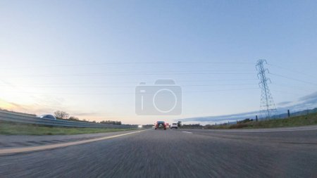 Photo for As the sun sets, driving on HWY 101 near Pismo Beach, California becomes a captivating experience with the sky painted in shades of orange and pink, casting a warm glow over the coastal landscape. - Royalty Free Image