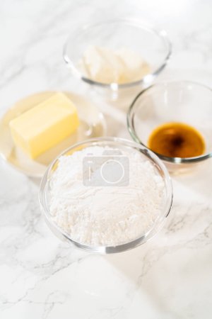Photo for Measured ingredients in glass mixing bowls to bake no-yeast cinnamon roll cupcakes. - Royalty Free Image