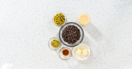 Téléchargez les photos : Flat lay. Measured ingredients in glass mixing bowls to make chocolate pistachio fudge. - en image libre de droit