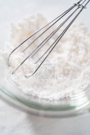 Foto de Mezclar los ingredientes con un batidor de mano para preparar el polvo de azúcar en polvo. - Imagen libre de derechos