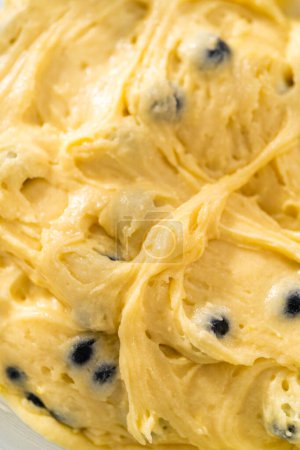 Photo for Mixing ingredients in a large glass mixing bowl to bake lemon blueberry bundt cake. - Royalty Free Image