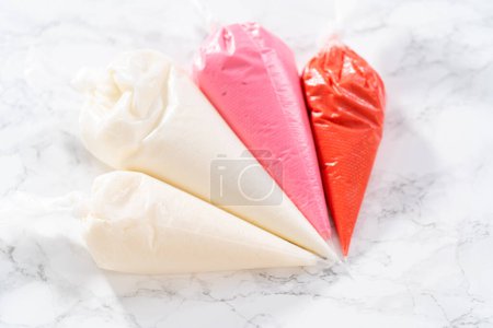 Photo for Homemade royal icing in piping bags ready to decorate sugar cookies on the kitchen counter. - Royalty Free Image