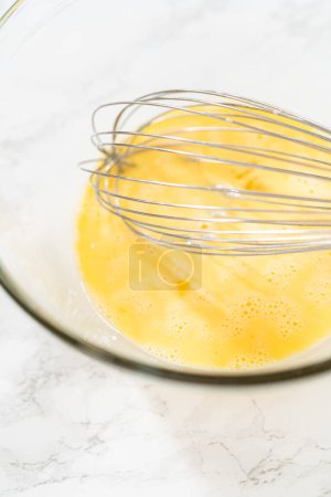 Téléchargez les photos : Une vue rapprochée des ingrédients savamment mélangés dans un grand bol à mélanger pour un gâteau de lapin de citrouille fait maison alléchant. - en image libre de droit