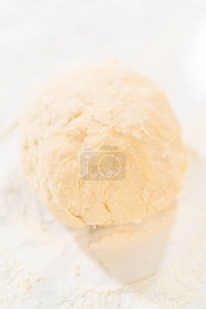 Foto de Rolling bread tough con un rodillo francés para hornear pasteles de canela sin levadura. - Imagen libre de derechos