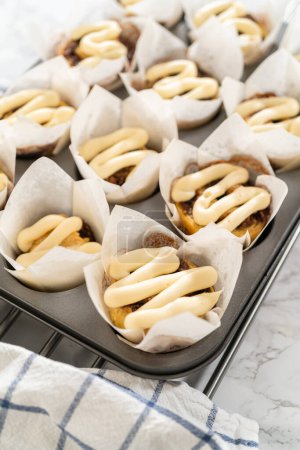 Foto de Adorne cupcakes de canela sin levadura con glaseado de queso crema de la bolsa de tuberías. - Imagen libre de derechos