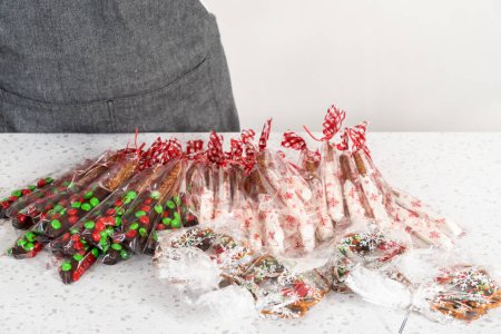Téléchargez les photos : Denver, Colorado, USA-December 18, 2022-Packaging homemade chocolate-covered pretzels into clear plastic bags for Christmas gifts. - en image libre de droit