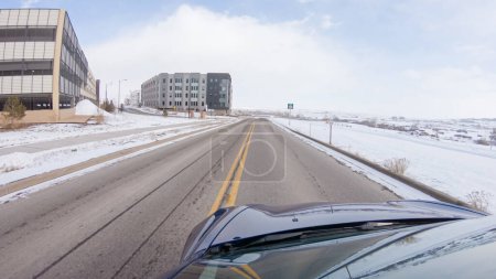 Téléchargez les photos : Centenaire, Colorado, États-Unis-30 janvier 2023-Naviguer sur une route de façade après la tempête hivernale offre une conduite sereine. Le paysage environnant, recouvert de neige, contribue au calme et au pittoresque - en image libre de droit