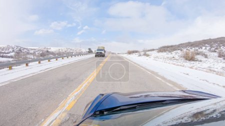 Foto de Castle Pines, Colorado, Estados Unidos-30 de enero de 2023-Navegar por una carretera de fachada tras la tormenta invernal ofrece un viaje sereno. El paisaje circundante, cubierto de nieve, contribuye a la paz y - Imagen libre de derechos