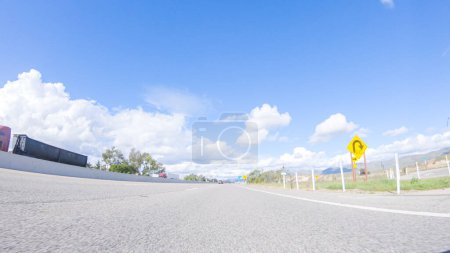Photo for Santa Maria, California, USA-December 6, 2022-On a crisp winter day, a car cruises along the iconic Highway 101 near San Luis Obispo, California. The surrounding landscape is brownish and subdued - Royalty Free Image