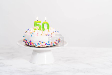 Téléchargez les photos : Petit gâteau d'anniversaire pour 50e anniversaire sur une assiette de gâteau blanc. - en image libre de droit
