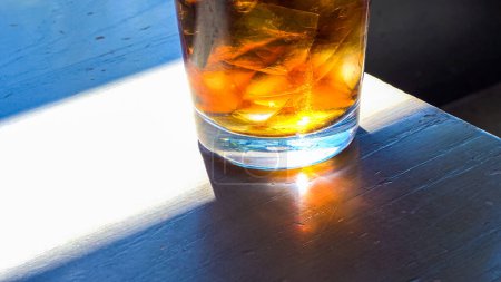 Photo for A close-up shot showcases a refreshing glass filled with ice cubes and soda pop, placed on a restaurant table, inviting the viewer to enjoy a cool and fizzy beverage. - Royalty Free Image