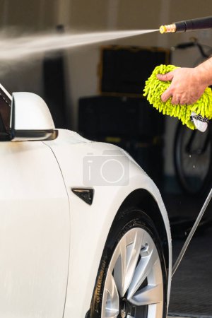 Photo for Denver, Colorado, USA-September 1, 2023-Efficiently cleaning an electric car in the comfort of a suburban driveway, combining eco-consciousness with practicality. - Royalty Free Image