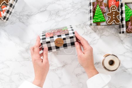 Téléchargez les photos : Pose plate. Emballage d'une variété maison de biscuits au caramel et au pain d'épice pour les cadeaux alimentaires de Noël dans des boîtes en papier. - en image libre de droit