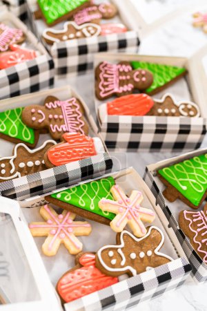 Téléchargez les photos : Emballage d'une variété maison de biscuits au caramel et au pain d'épice pour les cadeaux alimentaires de Noël dans des boîtes en papier. - en image libre de droit