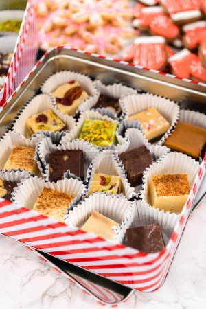 Téléchargez les photos : Emballage d'une variété maison de biscuits au caramel et au pain d'épice pour les cadeaux alimentaires de Noël dans des boîtes d'étain. - en image libre de droit