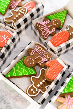 Téléchargez les photos : Emballage d'une variété maison de biscuits au caramel et au pain d'épice pour les cadeaux alimentaires de Noël dans des boîtes en papier. - en image libre de droit