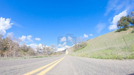 Téléchargez les photos : Le véhicule roule le long de la Cuyama Highway sous le soleil. Le paysage environnant est illuminé par le soleil radieux, créant une scène pittoresque et accueillante pendant que la voiture se déplace - en image libre de droit