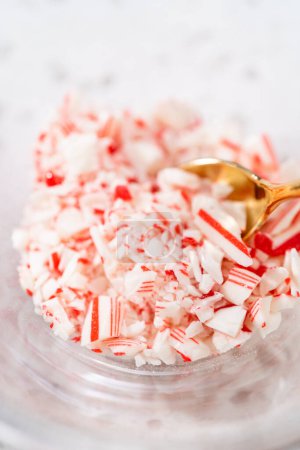 Measured ingredients in glass mixing bowls to make candy cane chocolate-covered pretzel rods.