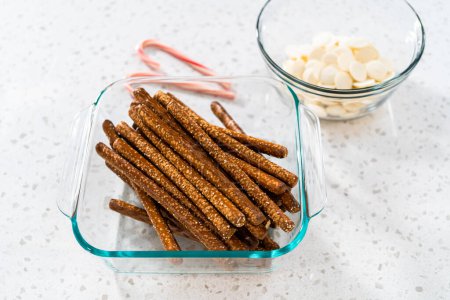 Foto de Ingredientes medidos en cuencos de vidrio para hacer barras de pretzel cubiertas de chocolate con caña de caramelo. - Imagen libre de derechos