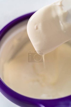 Téléchargez les photos : Fondre des pépites de chocolat dans un melting pot de bonbons pour fabriquer des tiges de bretzel recouvertes de chocolat de canne à bonbons. - en image libre de droit