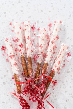Foto de Embalaje casero bastón de dulces barras de pretzel cubierto de chocolate en bolsas de plástico transparente para regalos de Navidad. - Imagen libre de derechos
