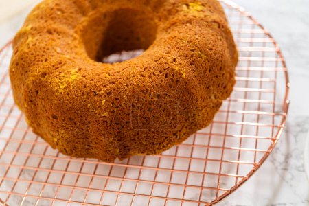 Photo for Cooling freshly baked pumpkin bundt cake on the kitchen counter. - Royalty Free Image
