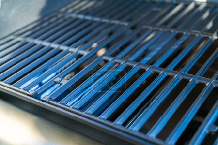 Photo for Close-up reveals the pristine griddle of a new two-burner grill, prominently displayed on the balcony of a suburban house, eagerly awaiting its first outdoor cooking adventure. - Royalty Free Image