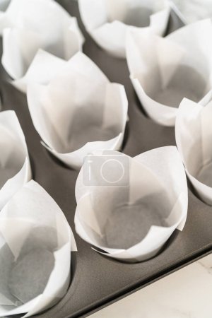 Foto de Forro de panecillo para hornear magdalenas con revestimientos de tulipán de papel para hornear cupcakes de canela sin levadura. - Imagen libre de derechos