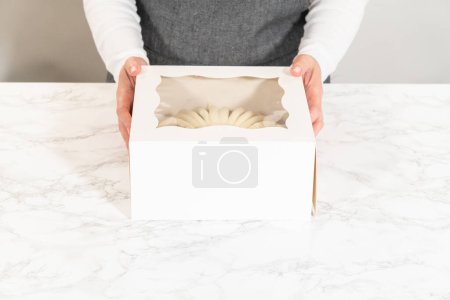 Foto de El pastel de zanahoria se envasa cuidadosamente en una caja de pastel de paquete de papel blanco, lista para regalar o compartir. - Imagen libre de derechos