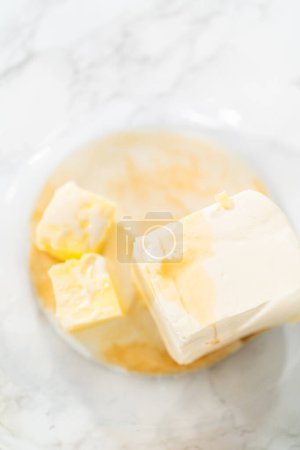 Photo for In a large mixing bowl, the ingredients are expertly mixed to create a delectable cream cheese buttercream for the Carrot Bundt Cake. - Royalty Free Image