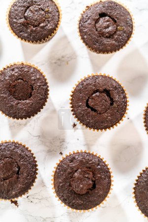 Téléchargez les photos : Chaque cupcake au chocolat reçoit une généreuse garniture de caramel succulent, ajoutant une couche supplémentaire de saveur et d'indulgence. - en image libre de droit