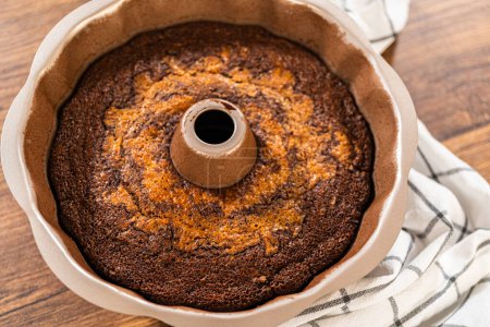Téléchargez les photos : Le gâteau de bundt de pain d'épice se refroidit gracieusement sur un support métallique, attendant son glaçage au caramel doux. - en image libre de droit