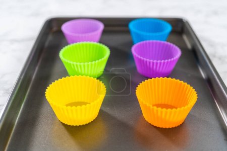 New silicone cupcake liners of different colors on the kitchen counter.