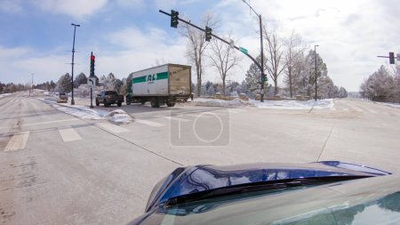 Foto de Castle Pines, Colorado, Estados Unidos-30 de enero de 2023-Tormenta post-invierno, el viaje en coche por una carretera suburbana ofrece un viaje tranquilo. La pintoresca escena, con nieve adornando el paisaje, se suma a la - Imagen libre de derechos