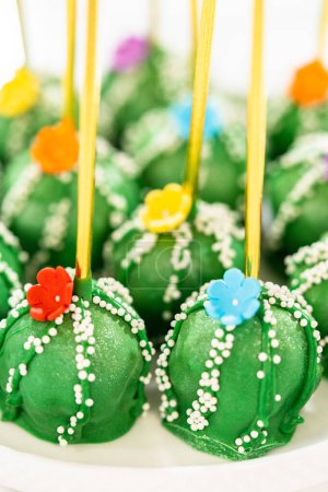 Téléchargez les photos : Gâteaux éclatants en forme de cactus, joliment décorés avec de la poussière de lustre, des fleurs de sucre et des paillettes blanches, arrangés pour célébrer Cinco de Mayo. - en image libre de droit