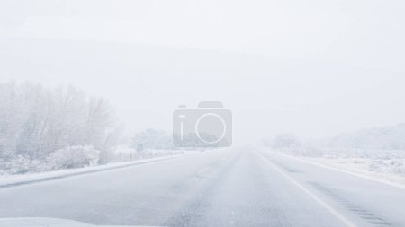 Foto de El vehículo POV-Electric es capturado hábilmente navegando por la carretera I-70 durante una tormenta de invierno en el oeste de Colorado. - Imagen libre de derechos