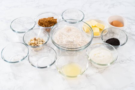 Foto de Ingredientes medidos en cuencos de vidrio para hornear magdalenas de semillas de amapola de limón. - Imagen libre de derechos