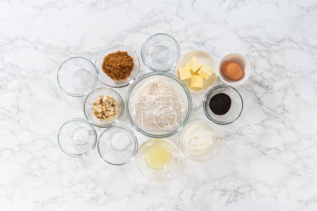 Foto de Acostado. Ingredientes medidos en cuencos de vidrio para hornear magdalenas de semillas de amapola de limón. - Imagen libre de derechos