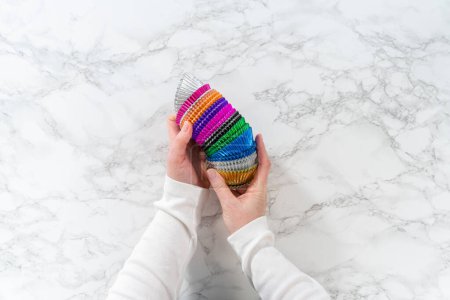 Photo for Flat lay. New foil cupcake liners of different colors on the kitchen counter. - Royalty Free Image