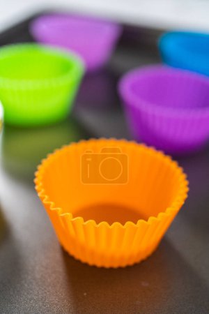 New silicone cupcake liners of different colors on the kitchen counter.