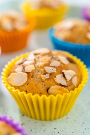 Photo for Freshly baked lemon poppy seed muffins garnished with almond slivers on the kitchen counter. - Royalty Free Image