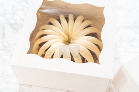 Foto de Los pasteles recién horneados se encuentran cuidadosamente enclavados en cajas de papel blanco, preparándolas para un transporte seguro mientras mantienen su aspecto delicioso.. - Imagen libre de derechos