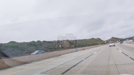Photo for Driving along Highway 101 near Rincon Beach, California, amidst a gloomy, cloudy winter day. - Royalty Free Image