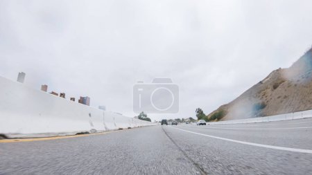 Foto de En medio de un día lluvioso de invierno, conducir en HWY 134 cerca de Los Ángeles, California, captura la atmósfera a través de lentes cubiertas de gotas de lluvia, agregando una perspectiva única y malhumorada al viaje. - Imagen libre de derechos