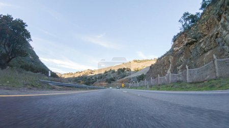 Die Fahrt auf dem HWY 1 in der Nähe von Las Cruces, Kalifornien, in der Schönheit eines sonnigen Wintertages bietet einen atemberaubenden Blick auf die malerische Küstenlandschaft vor dem Hintergrund eines klaren blauen Himmels.
