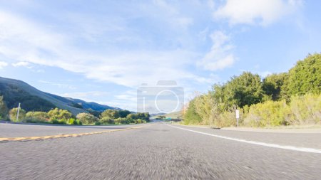 Basking in the beauty of a sunny winter day, driving on HWY 1 near Las Cruces, California offers stunning views of the picturesque coastal landscape against a backdrop of clear blue skies.