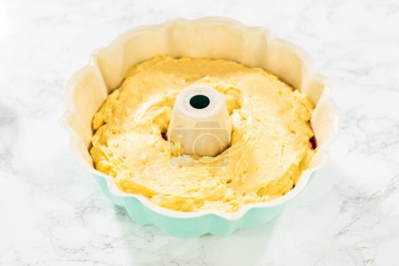 After greasing the bundt cake pan, its time to fill it with the prepared cake batter and delightful raspberry cake filling - creating a perfect harmony of flavors.