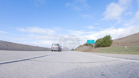 Téléchargez les photos : Santa Maria, Californie, États-Unis-6 décembre 2022-Par une belle journée d'hiver, une voiture parcourt l'emblématique Highway 101 près de San Luis Obispo, en Californie. Le paysage environnant est brunâtre et tamisé - en image libre de droit